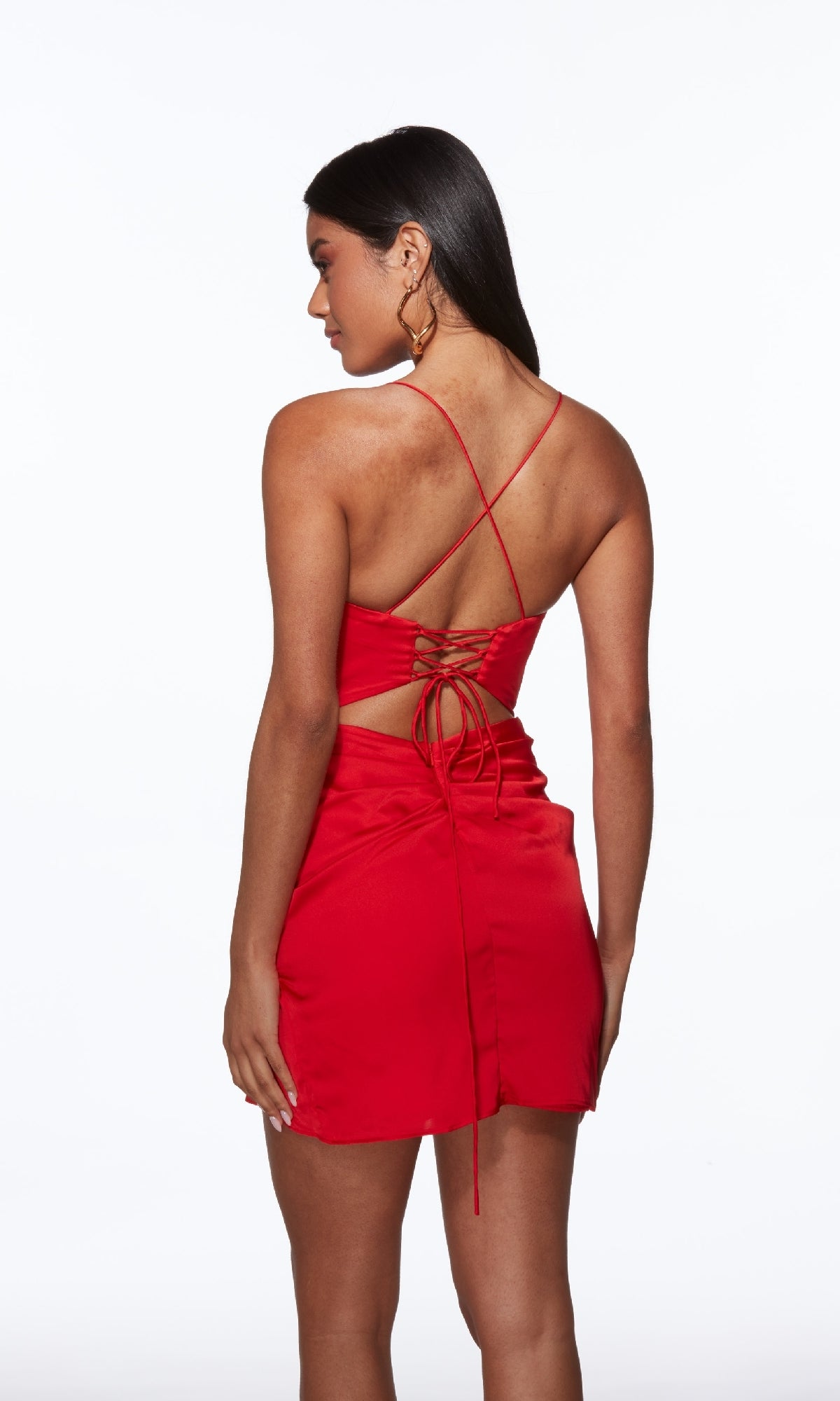 Woman wearing the Alyce 40099 Faux-Wrap Short Tulip Hoco Dress, a red mini dress with crisscross straps and lace-up back detail, standing against a white background.